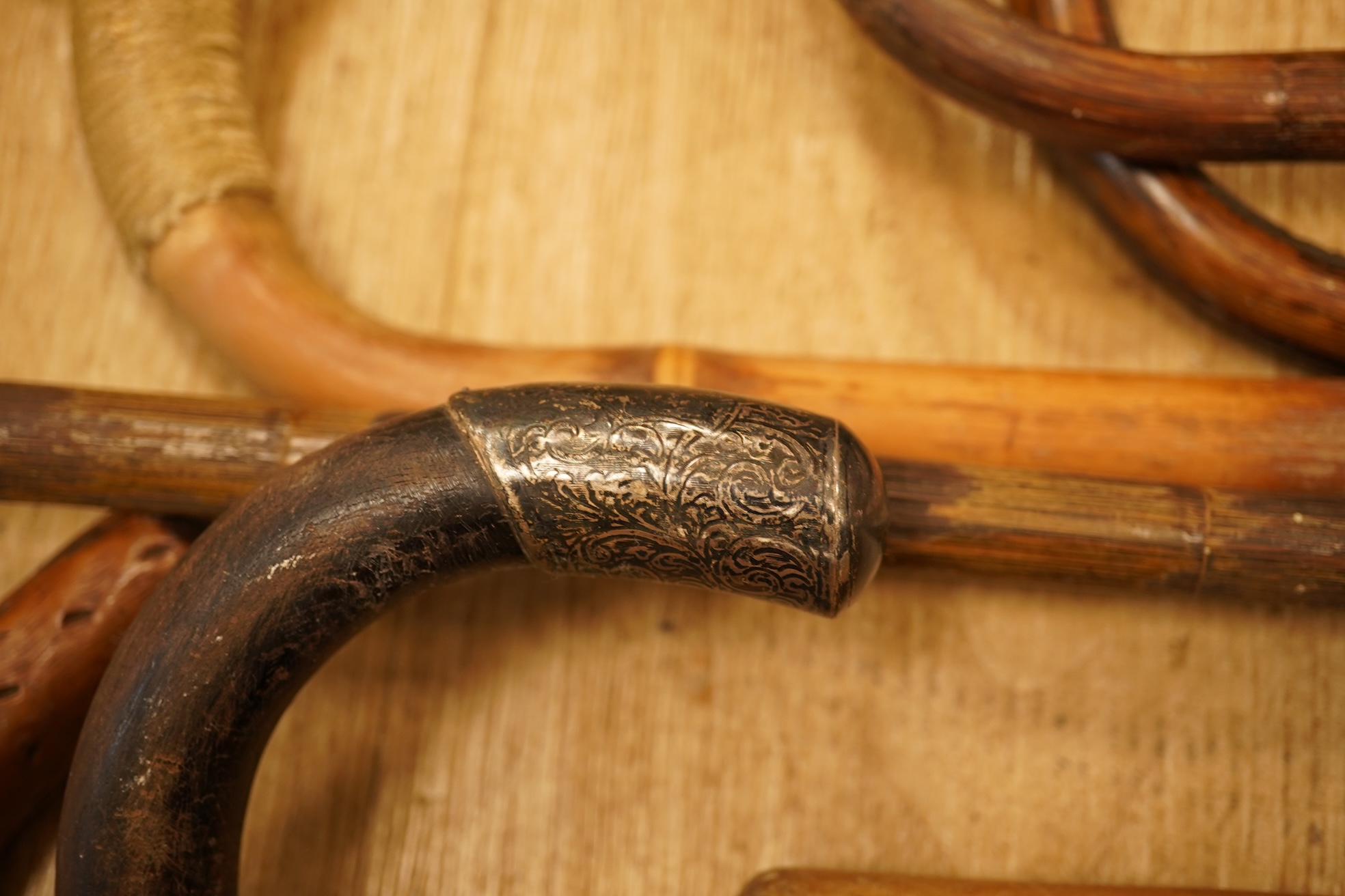 A collection of eleven carved walking sticks, some silver mounted